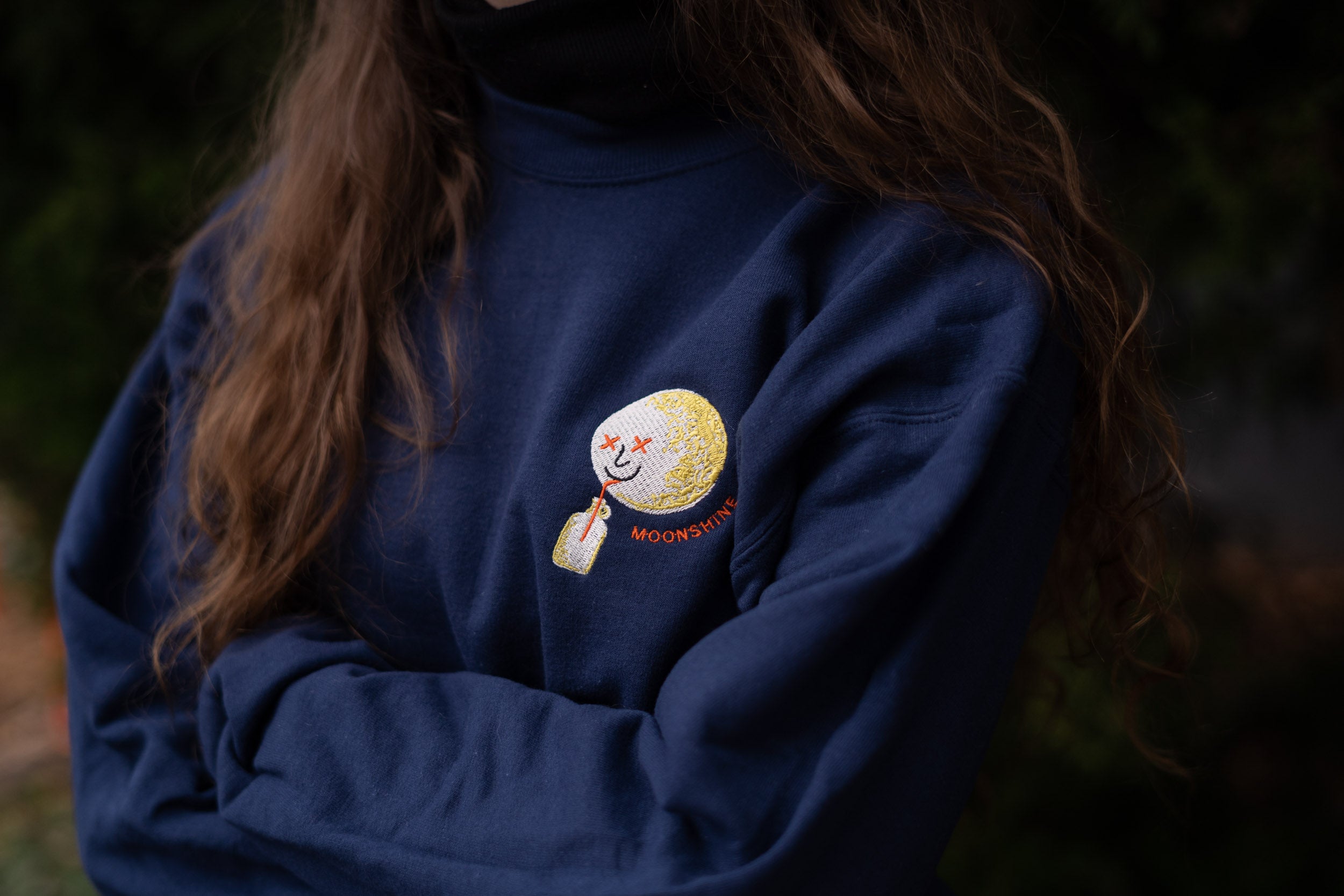 Model cross armed wearing a Moonshine Moonman Embroidered Sweatshirt